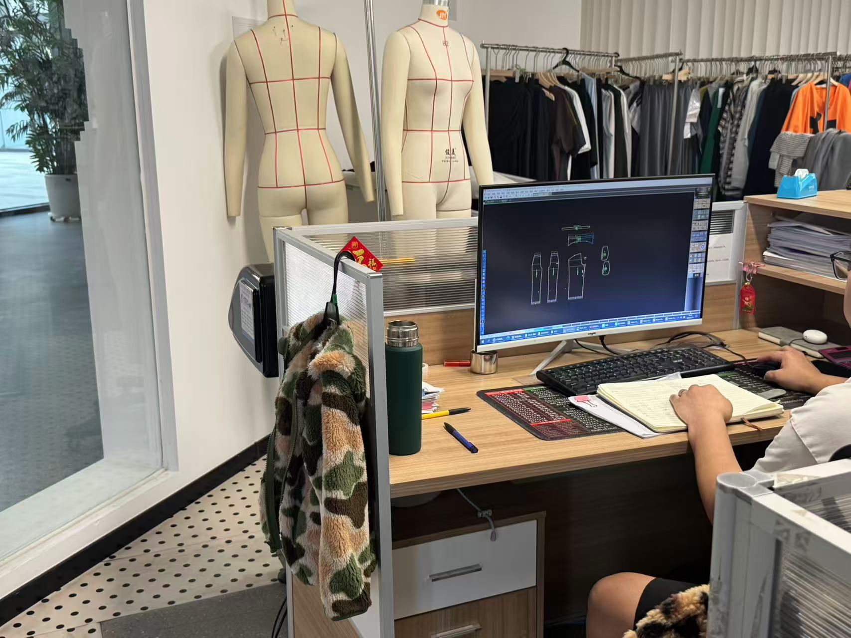 Technician developing a garment pattern on CAD software at a design workstation