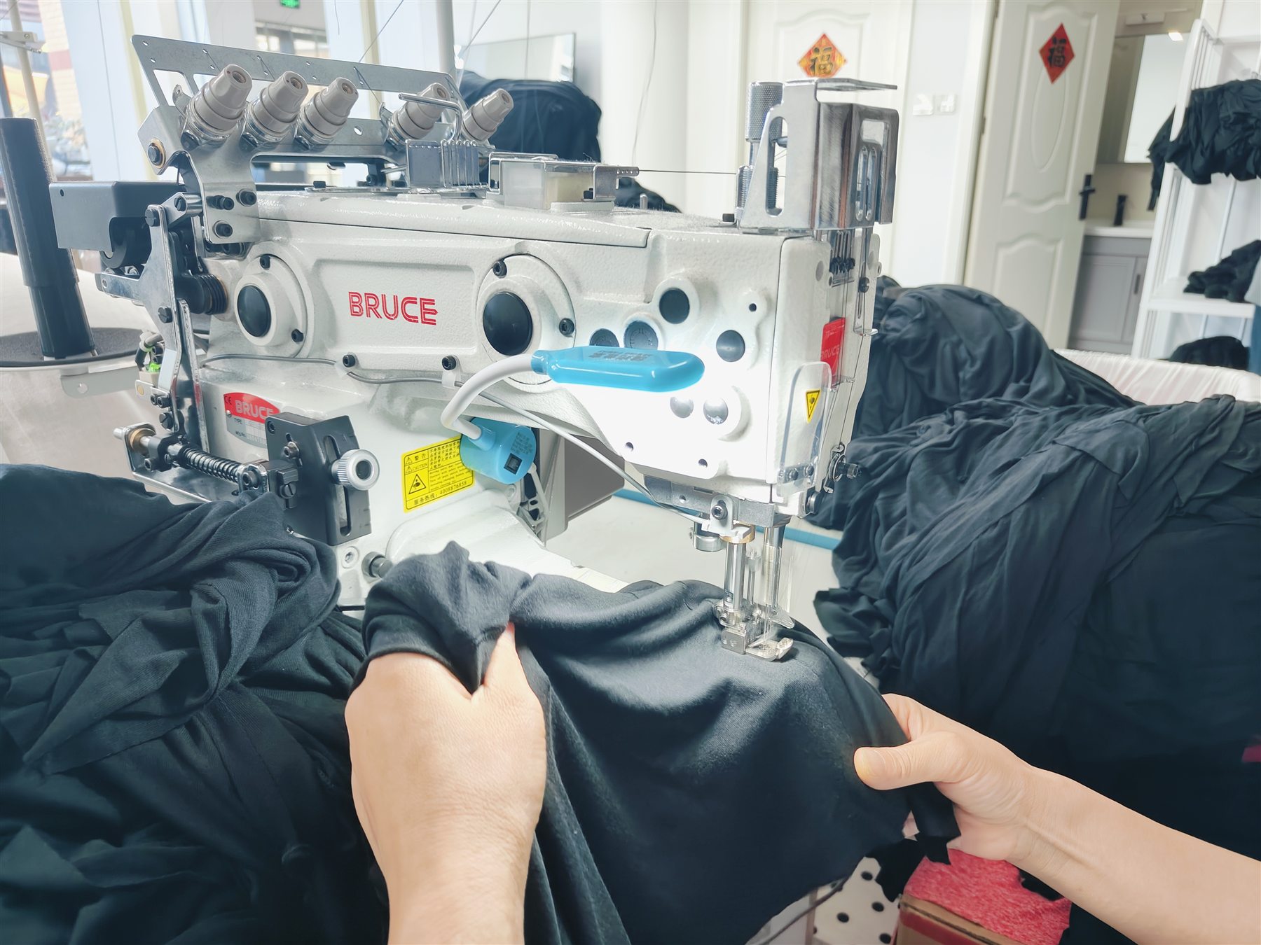 Operator finishing a white knit panel with an overlock machine